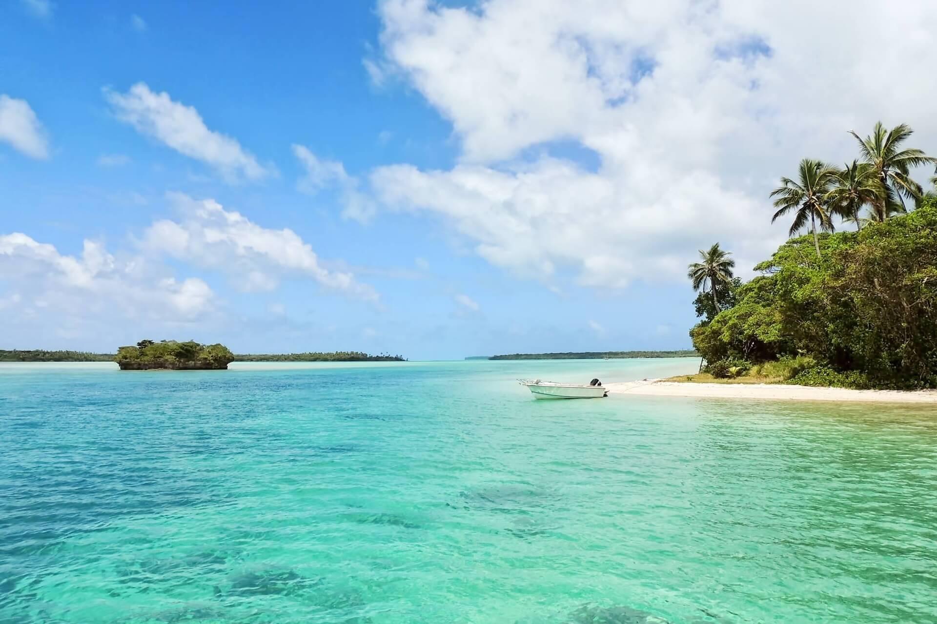 View of a turquoise crystal-clear sea, a boat and islands