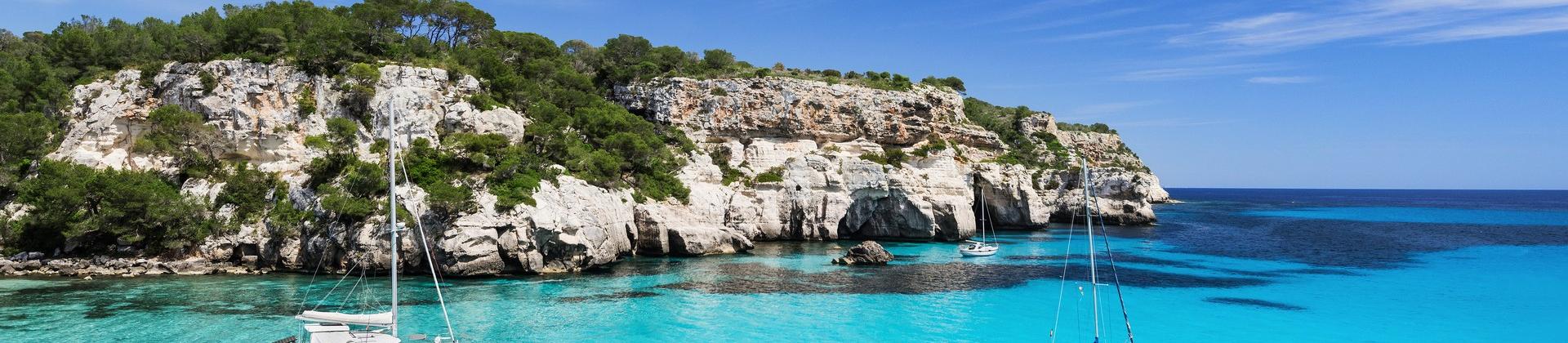 Beach with turquise water in Menorca on a sunny day with some clouds