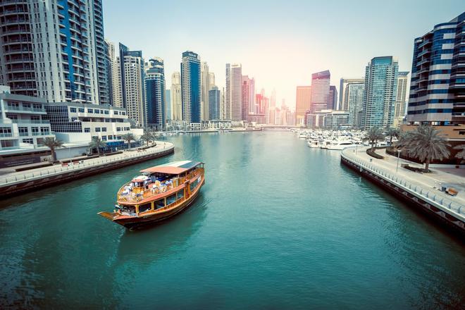 A boat sailing on the water, surrounded by skyscrapers, in the middle of Dubai city