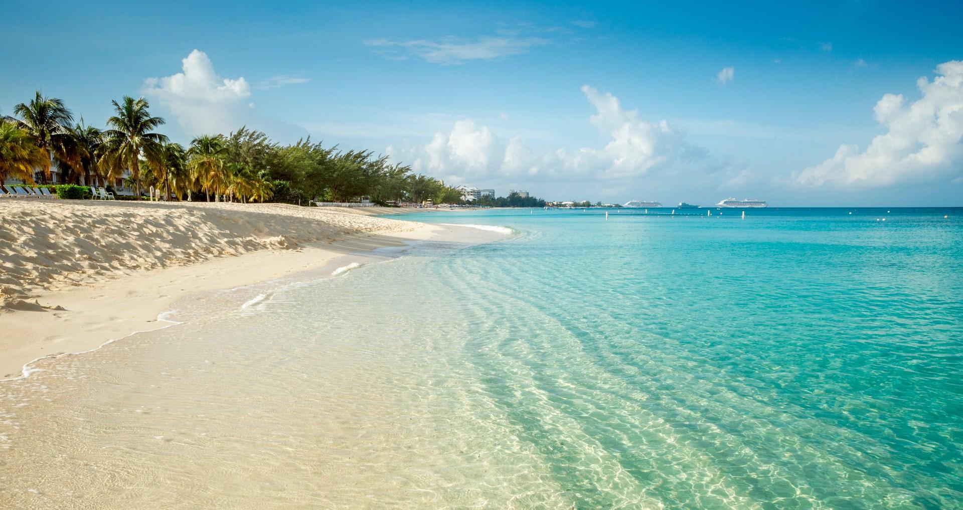 Amazing beach with turquise water in Grand Cayman in partly cloudy weather