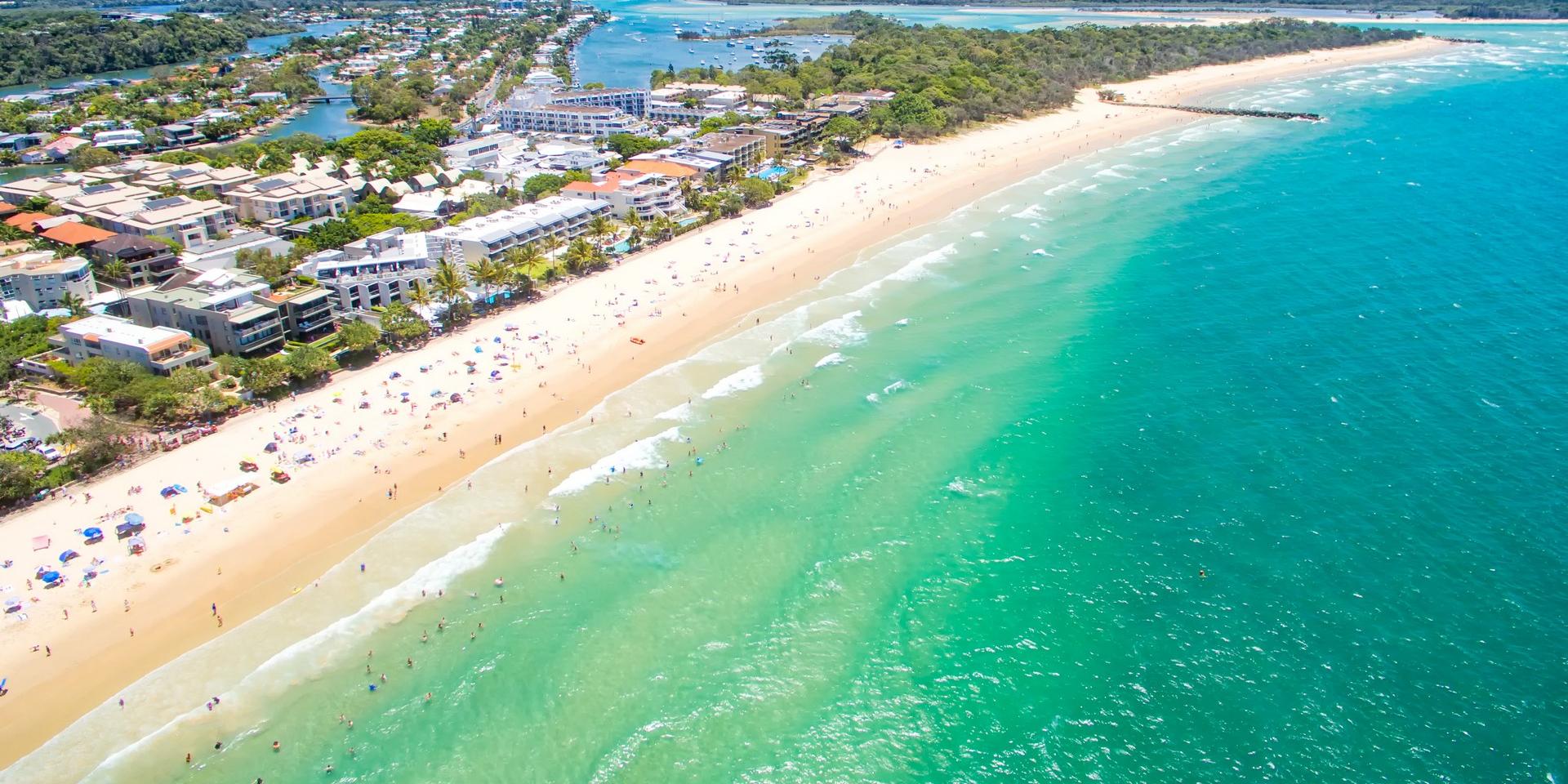 Aerial view of beach with a lot of people in Noosa Heads in sunny weather with few clouds