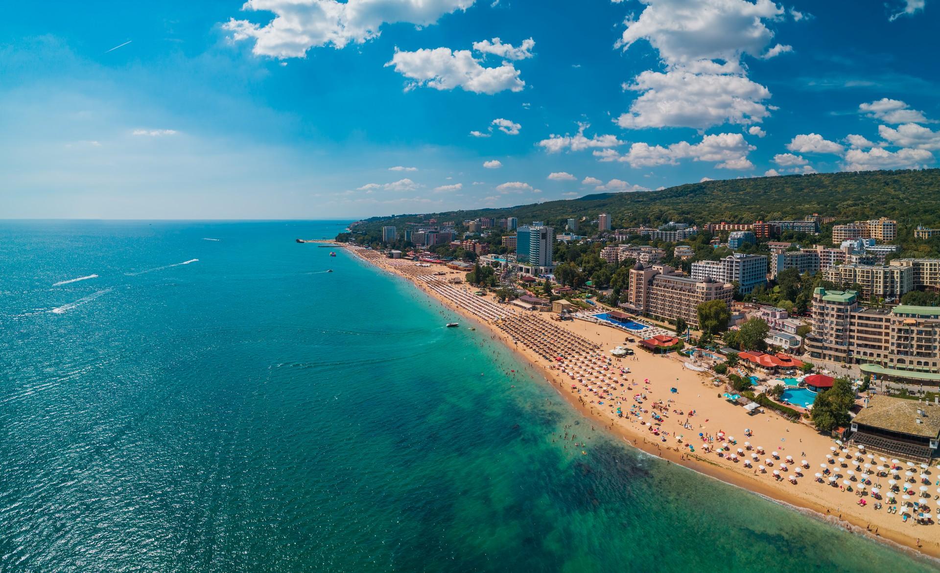 Aerial view of people on the beach in Zlatni Pyasatsi on a sunny day with some clouds