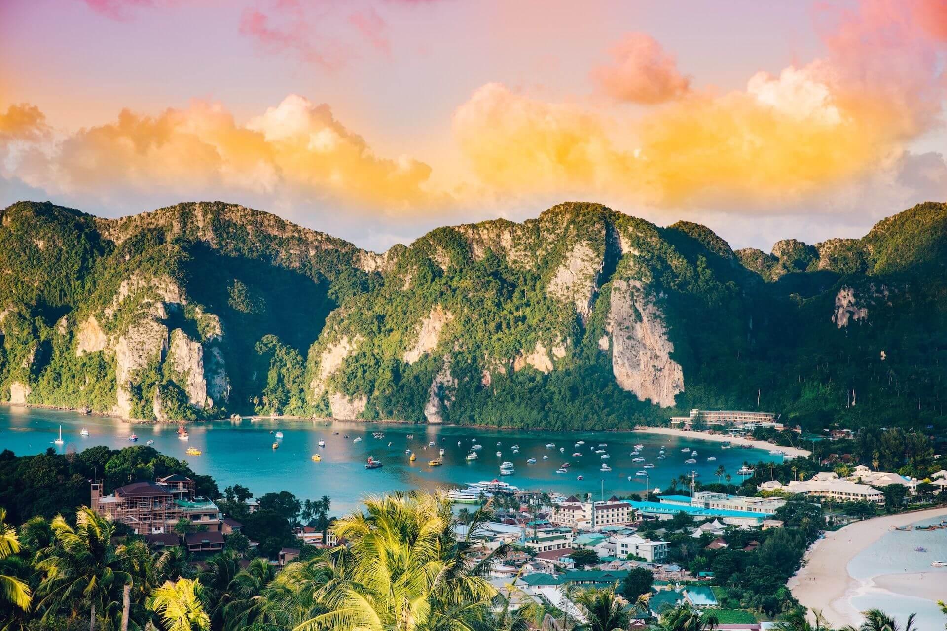 View of mountains, houses, sea with boats and beaches in Thailand