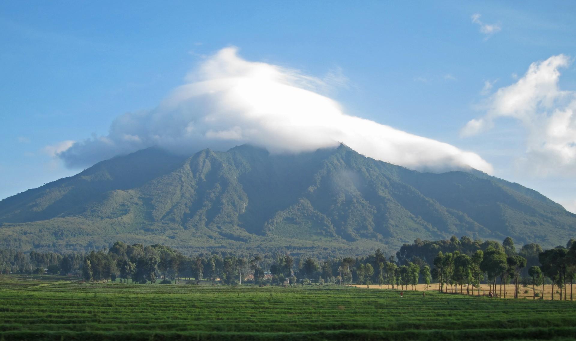 Mountain range in Parc National des Volcans on a sunny day with some clouds