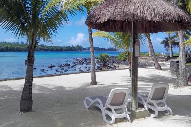 Bamboo umbrella with deckchairs located on a beach in Mauritius